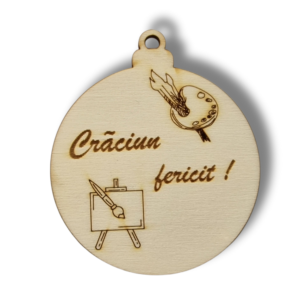 glob bej de Crăciun din lemn cu un șevalet si paleta de culori cu pensule pe el si mesajul "Crăciun fericit!"