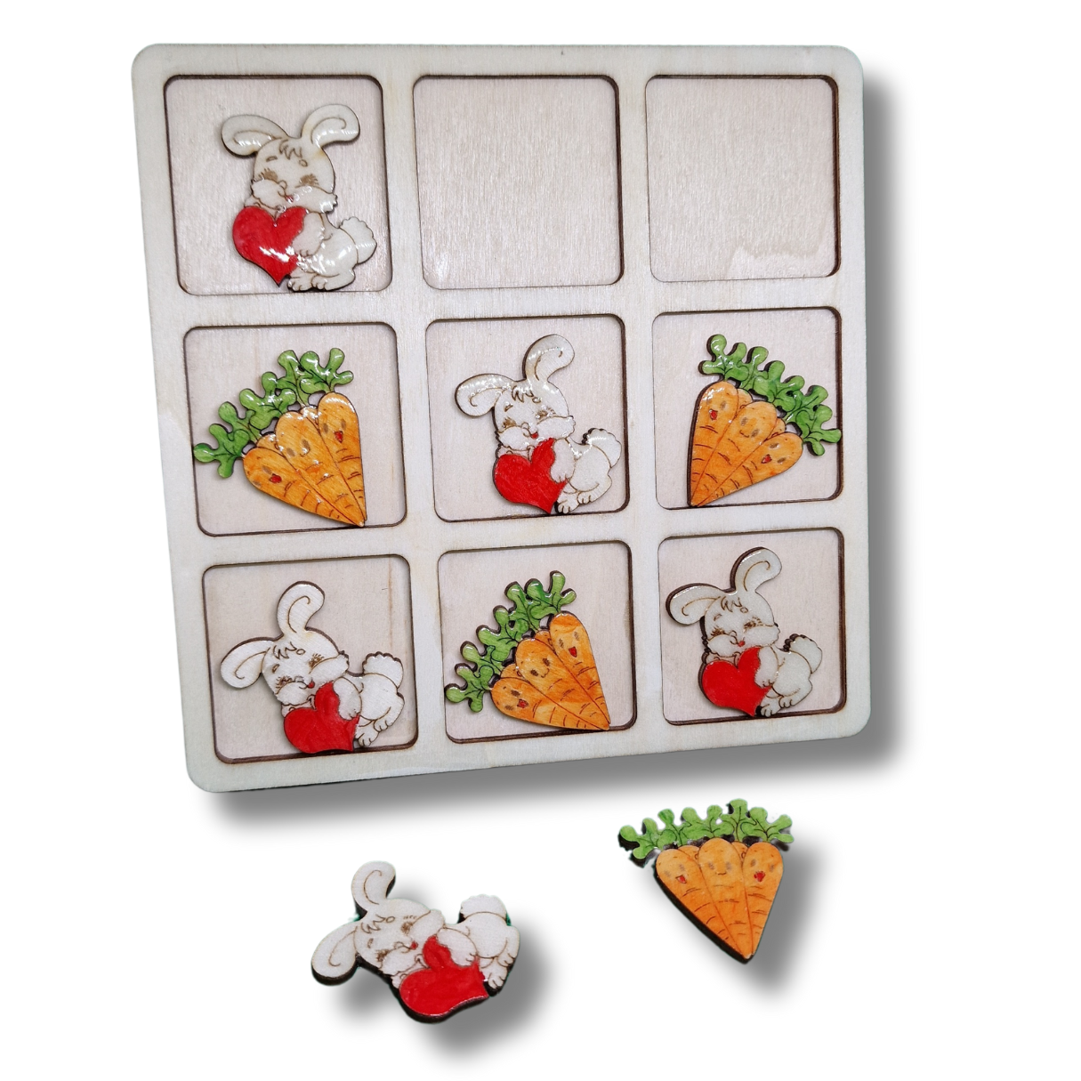 joc din lemn cu x si 0 cu piese in forma de iepuraș cu o inimioara roșie in brațe si morcovi