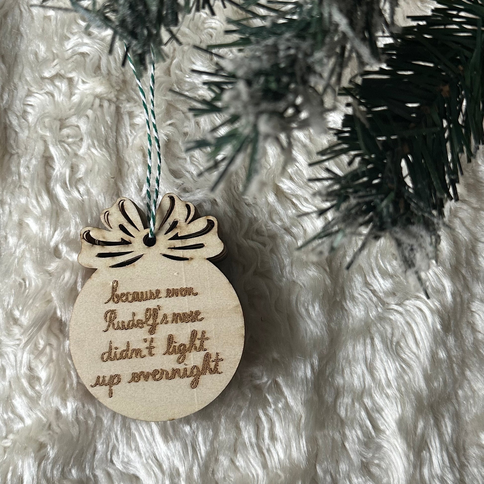 glob de Crăciun din lemn cu funda si textul "because even Rudolf's nose didn't light up overnight"